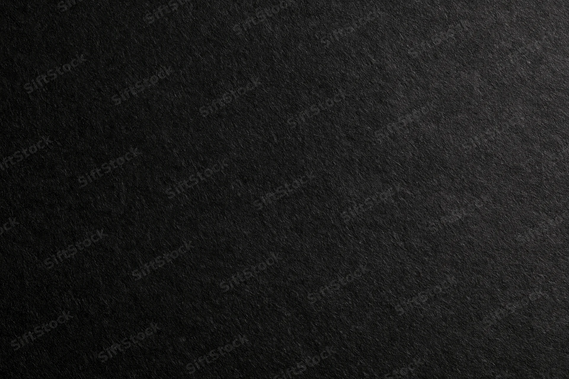 Close-up of dark charcoal black paper texture filling the frame