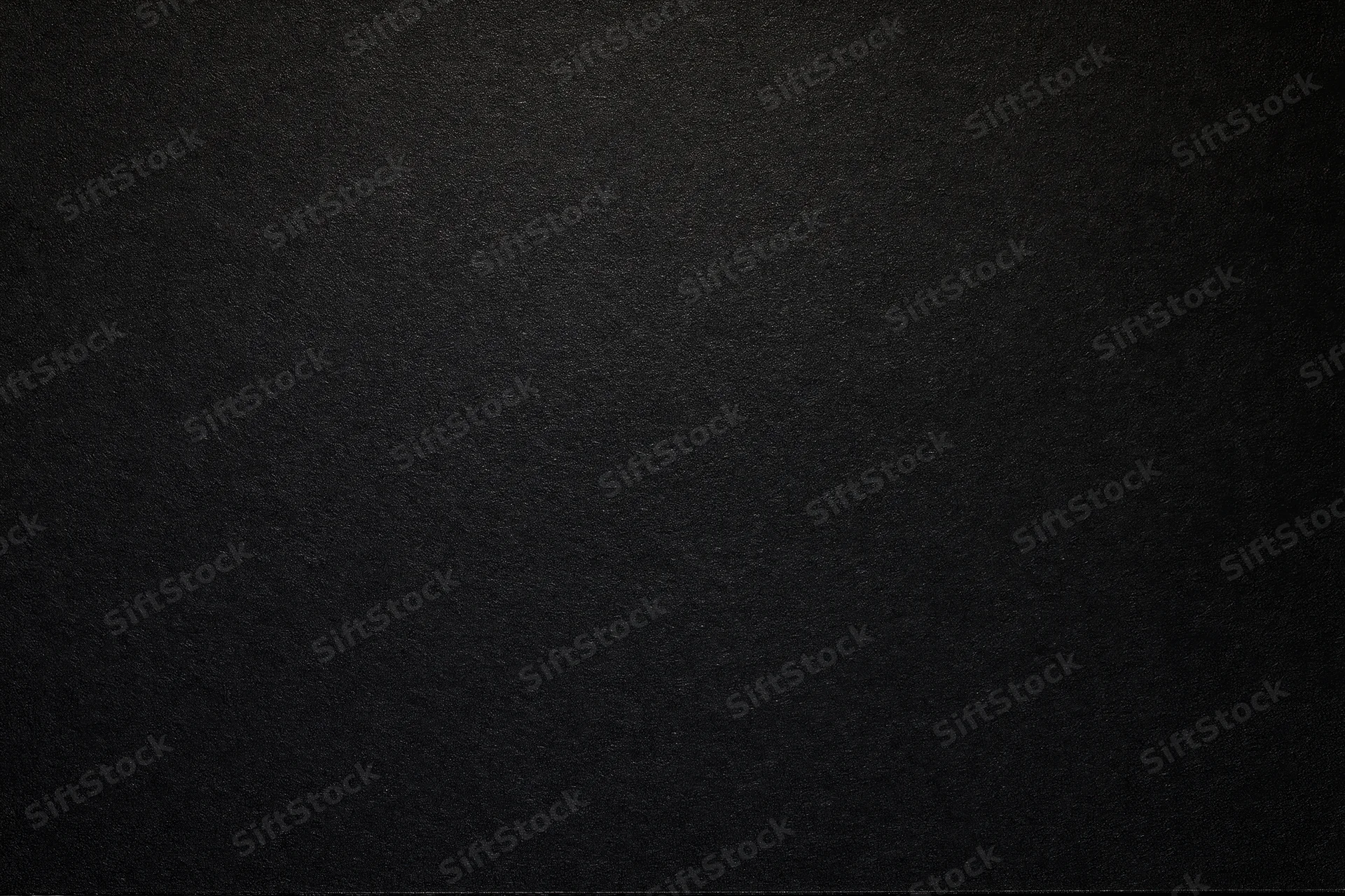 Close-up flat lay of matte black textured paper surface