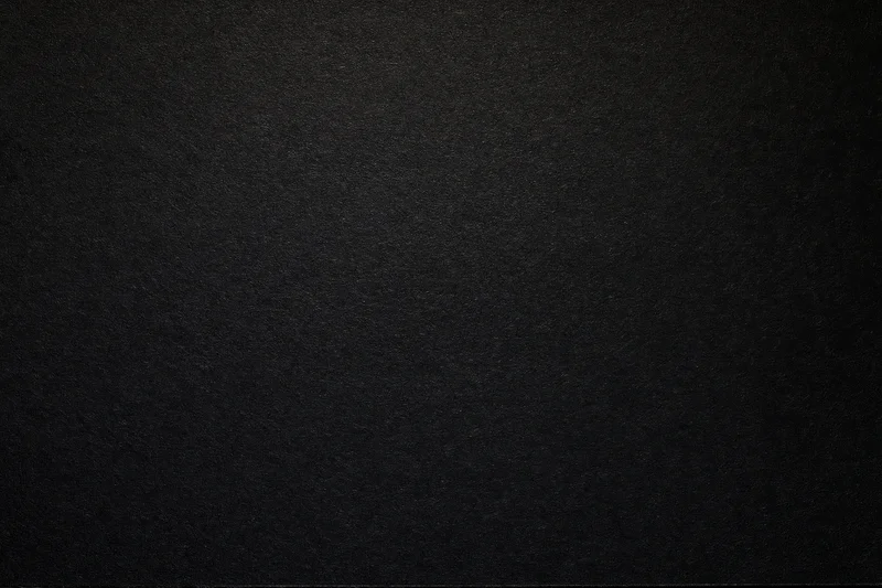 Close-up flat lay of matte black textured paper surface