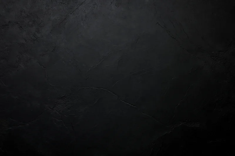 Close-up of dark cracked concrete wall surface