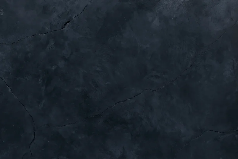 Close-up of cracked dark concrete wall surface