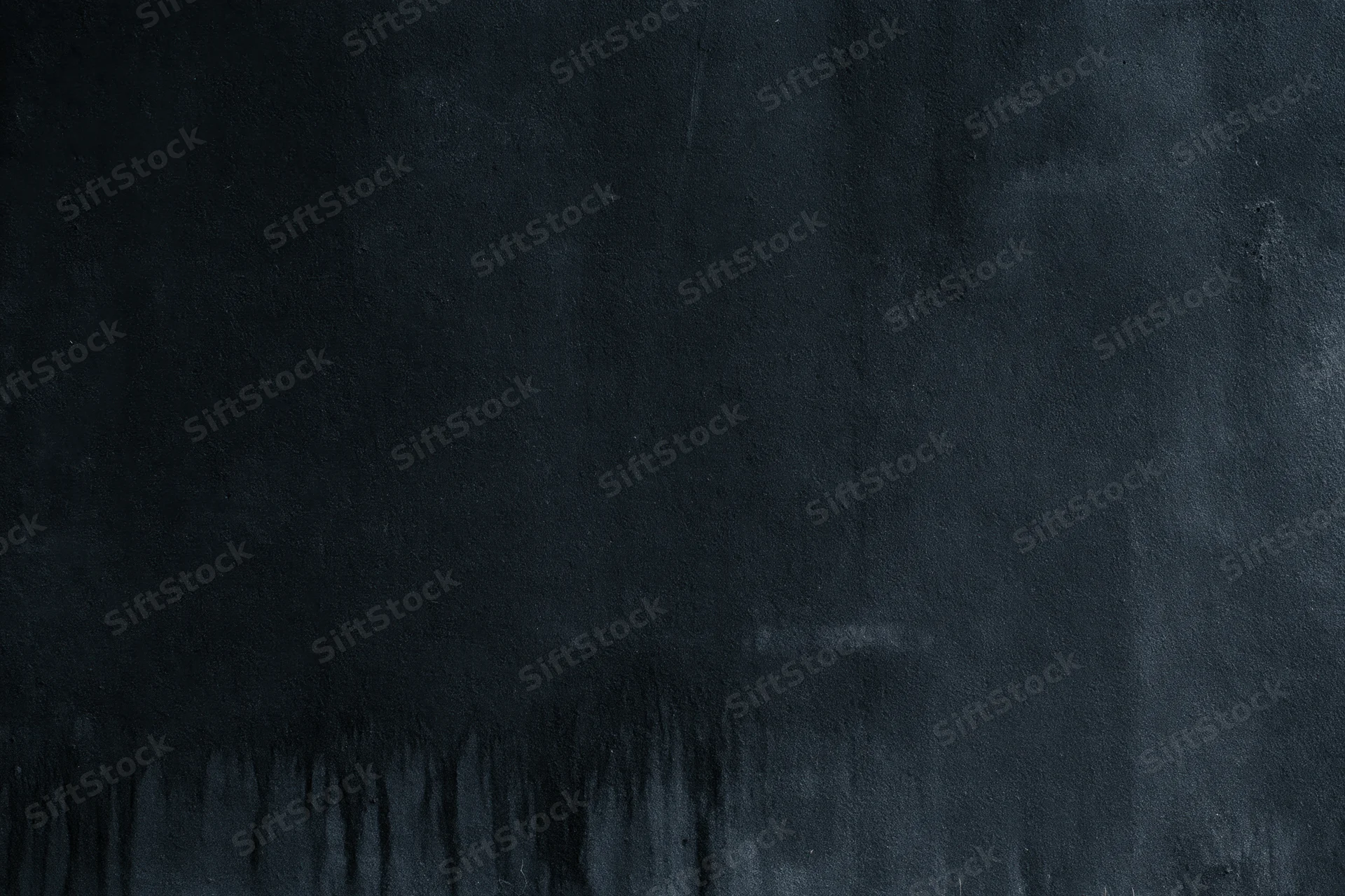 Dark matte concrete surface with rough texture and subtle stains