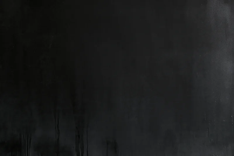 Dark matte concrete surface with weathered texture and subtle streaks