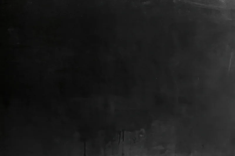 Close-up of dark matte concrete or metal surface with scratches and weathering