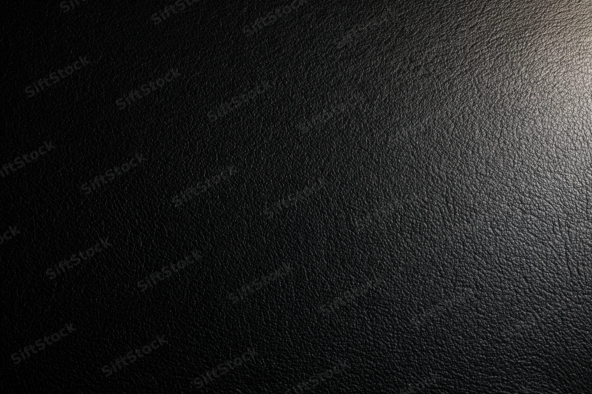 Close-up of black leather surface texture with visible grain pattern