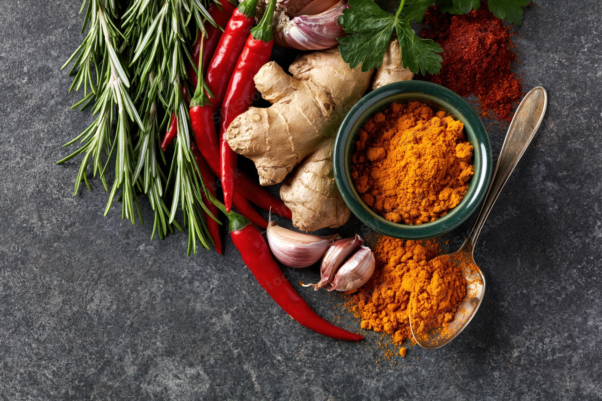 Cooking ingredients arranged along the left edge of a dark surface with copyspace on the right