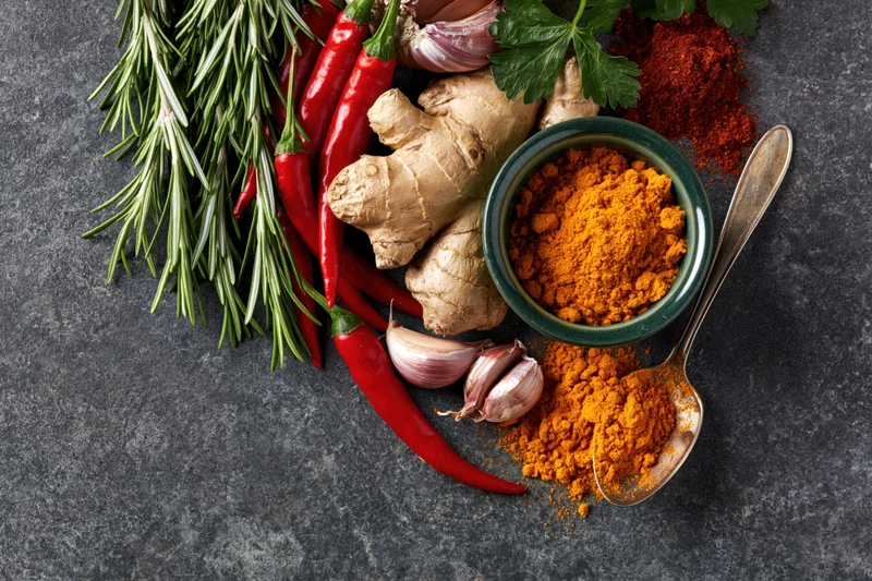 Cooking ingredients arranged along the left edge of a dark surface with copyspace on the right