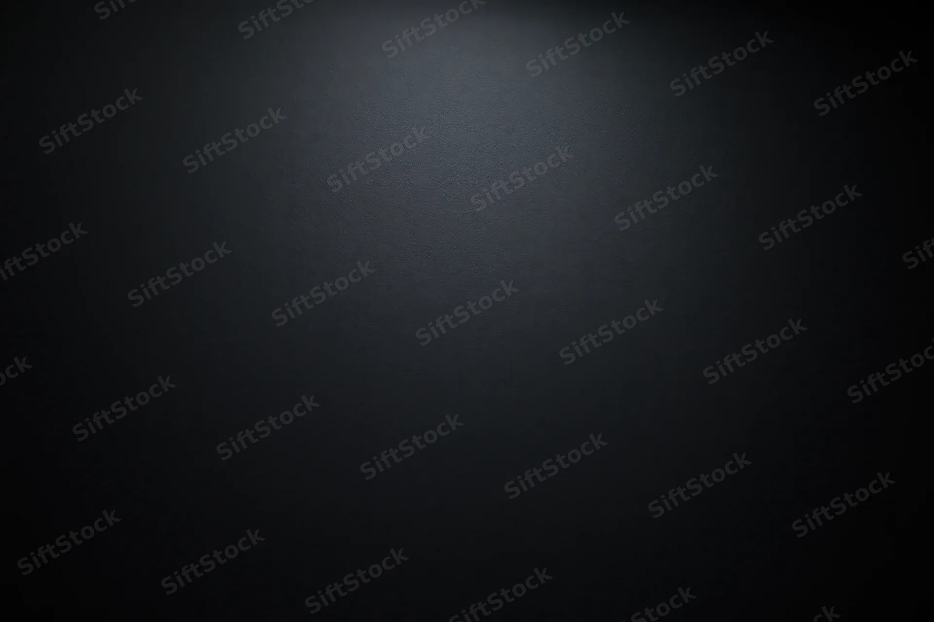 Dark charcoal matte surface with spotlight gradient filling the frame