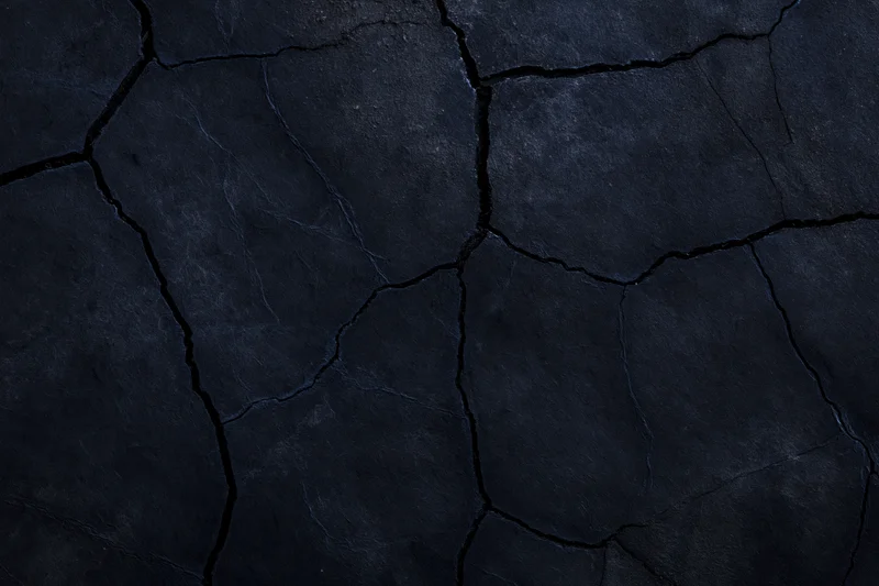 Dark cracked stone surface filling the frame as a textured background