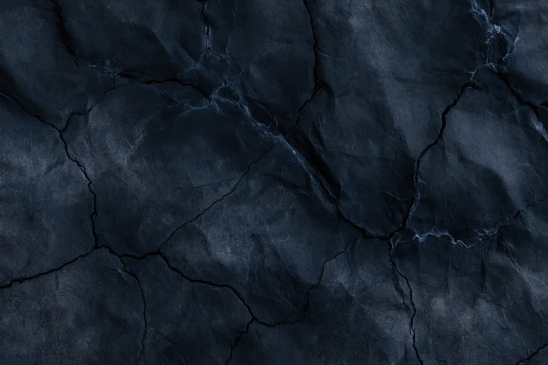 Dark cracked stone texture filling the frame as a seamless background