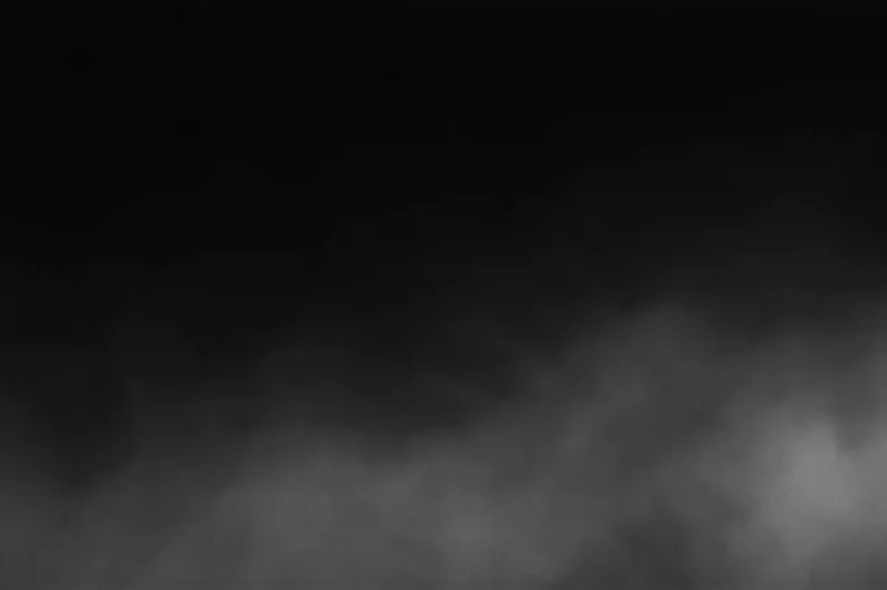Dense fog drifting across a dark empty surface wide