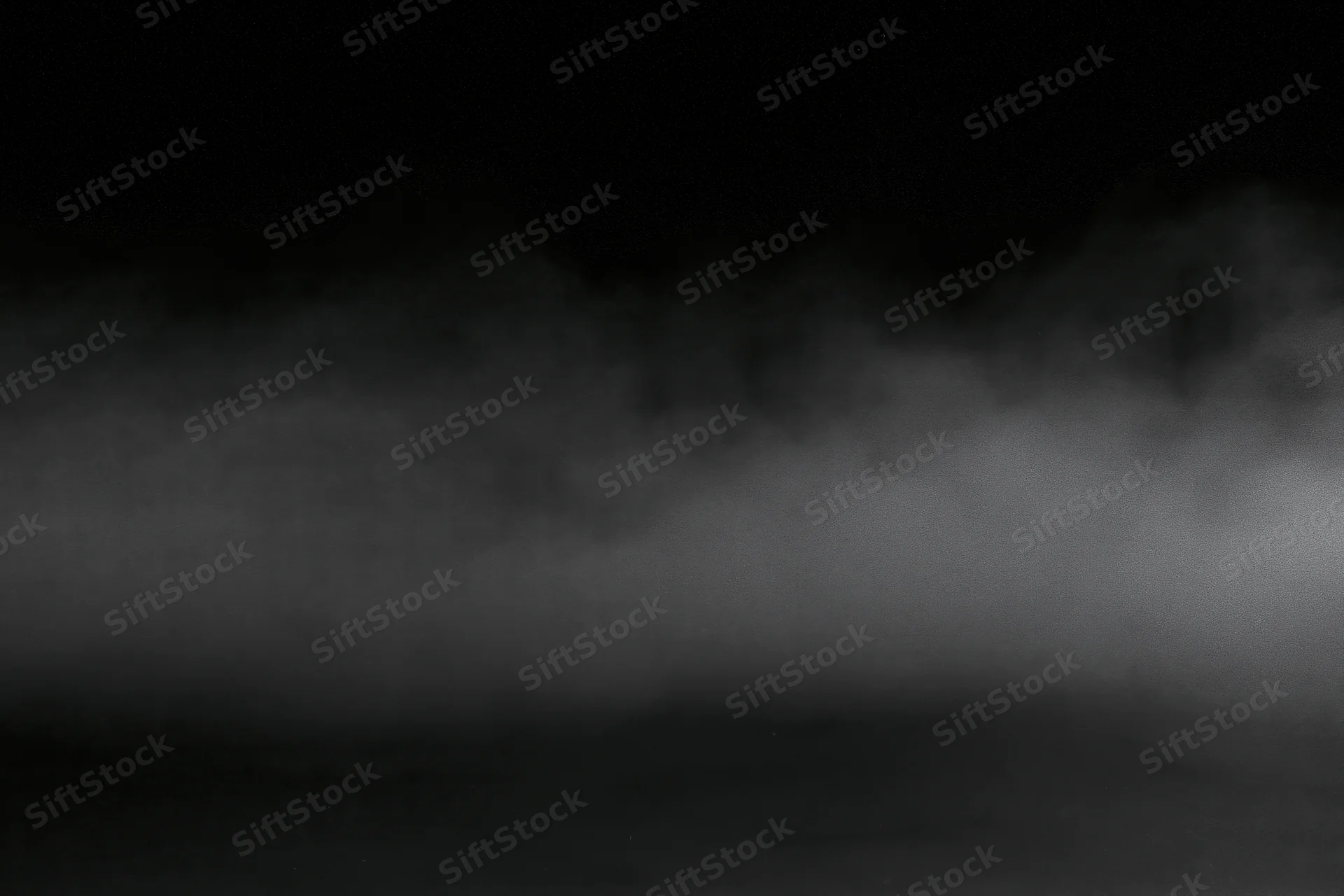Dense fog drifting across a dark empty surface at night