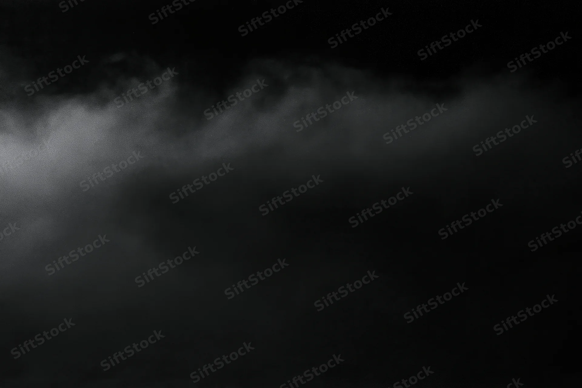 Dense fog drifting across a dark empty surface at night