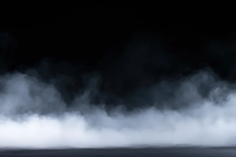Dense white smoke drifting low across a dark flat surface