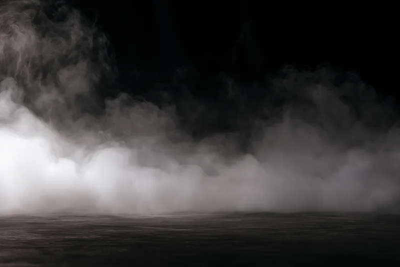 Dense white smoke drifting low across a dark flat surface