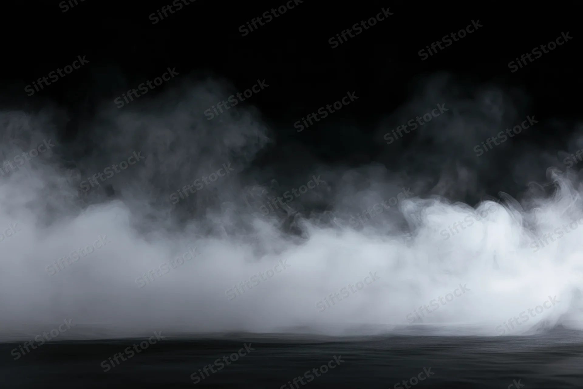 Dense white smoke drifting low across a dark surface