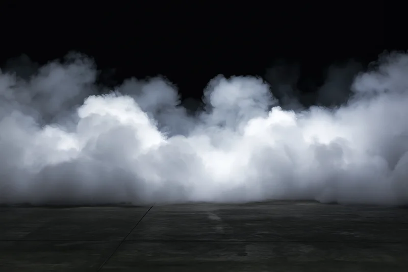 Dense white smoke rising from a dark concrete floor