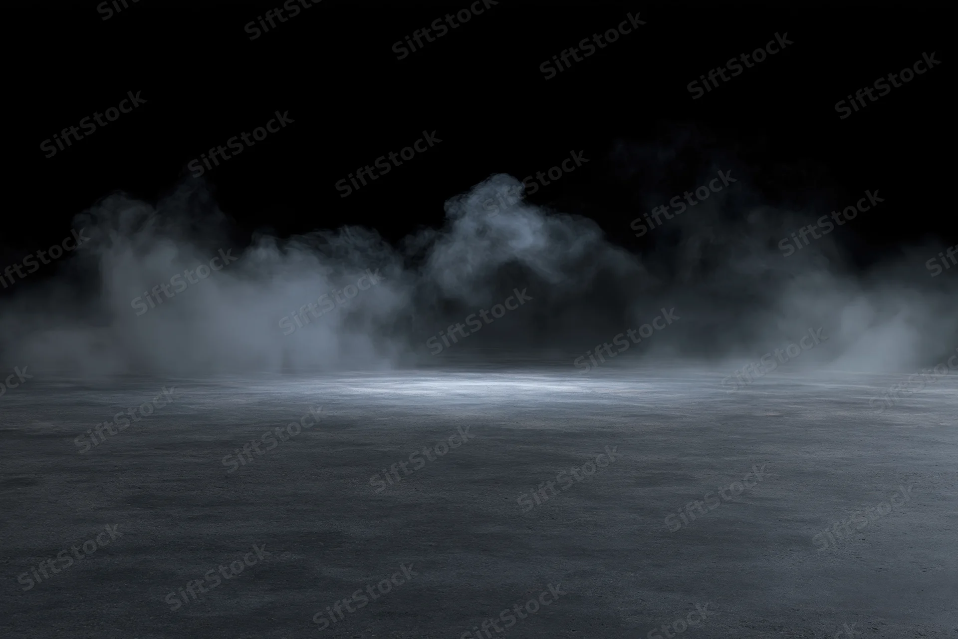 Wisps of smoke rising over a dark concrete floor in a dimly lit space