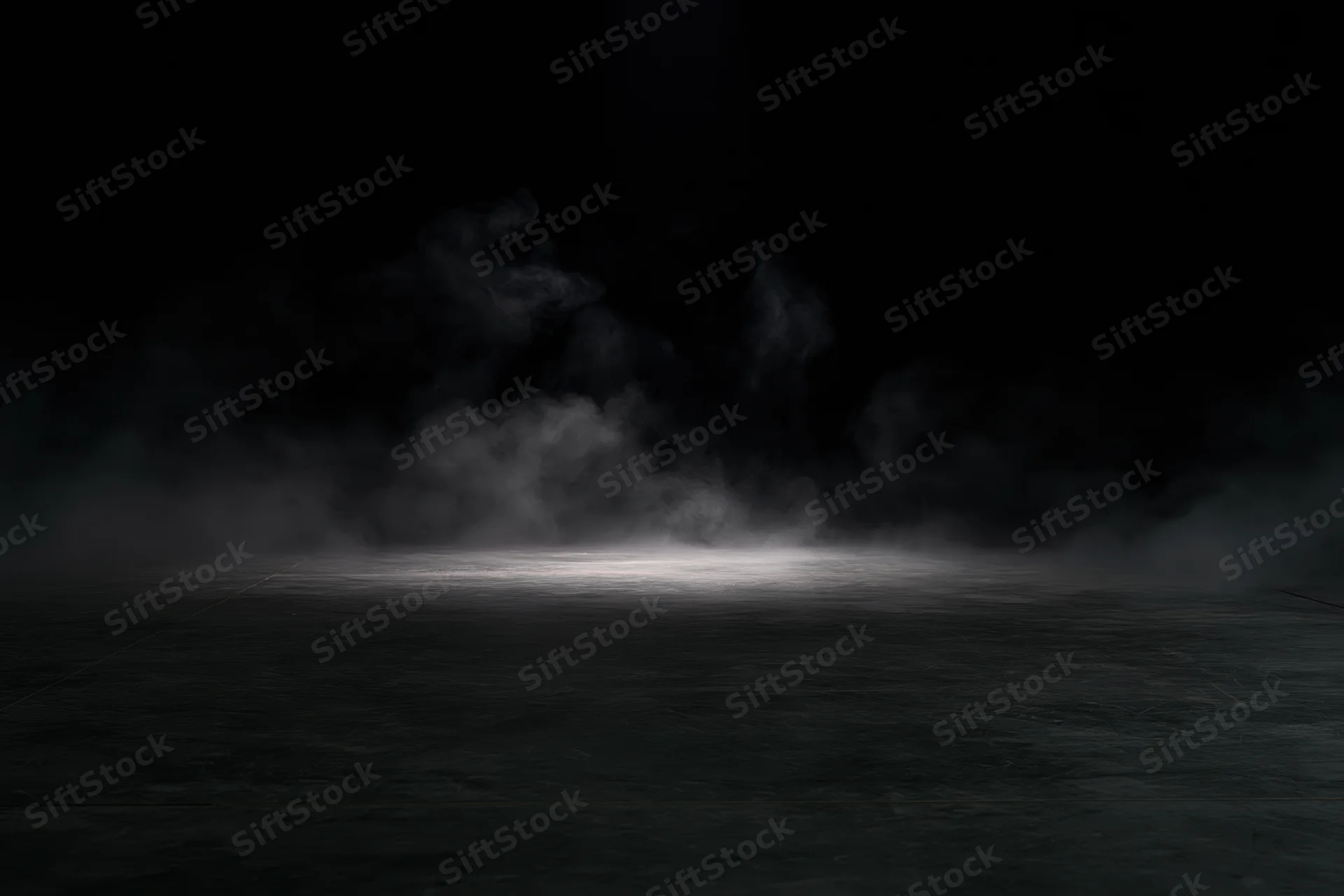 Smoke rising from a dark concrete floor under a spotlight