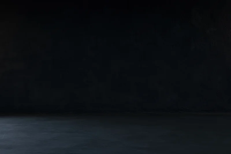 Dark empty room with textured concrete wall and floor