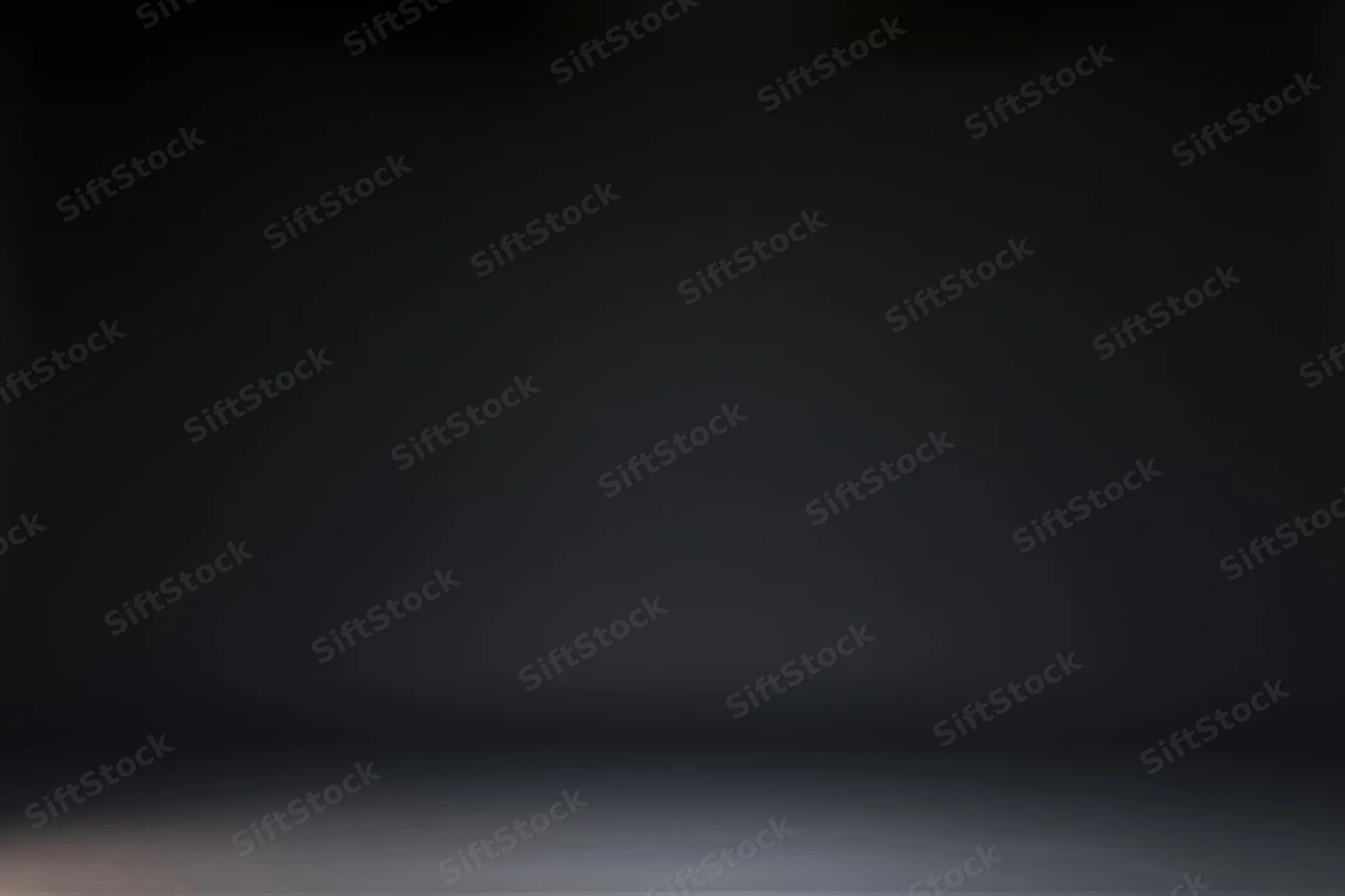 Empty dark studio backdrop with seamless black gradient and floor surface