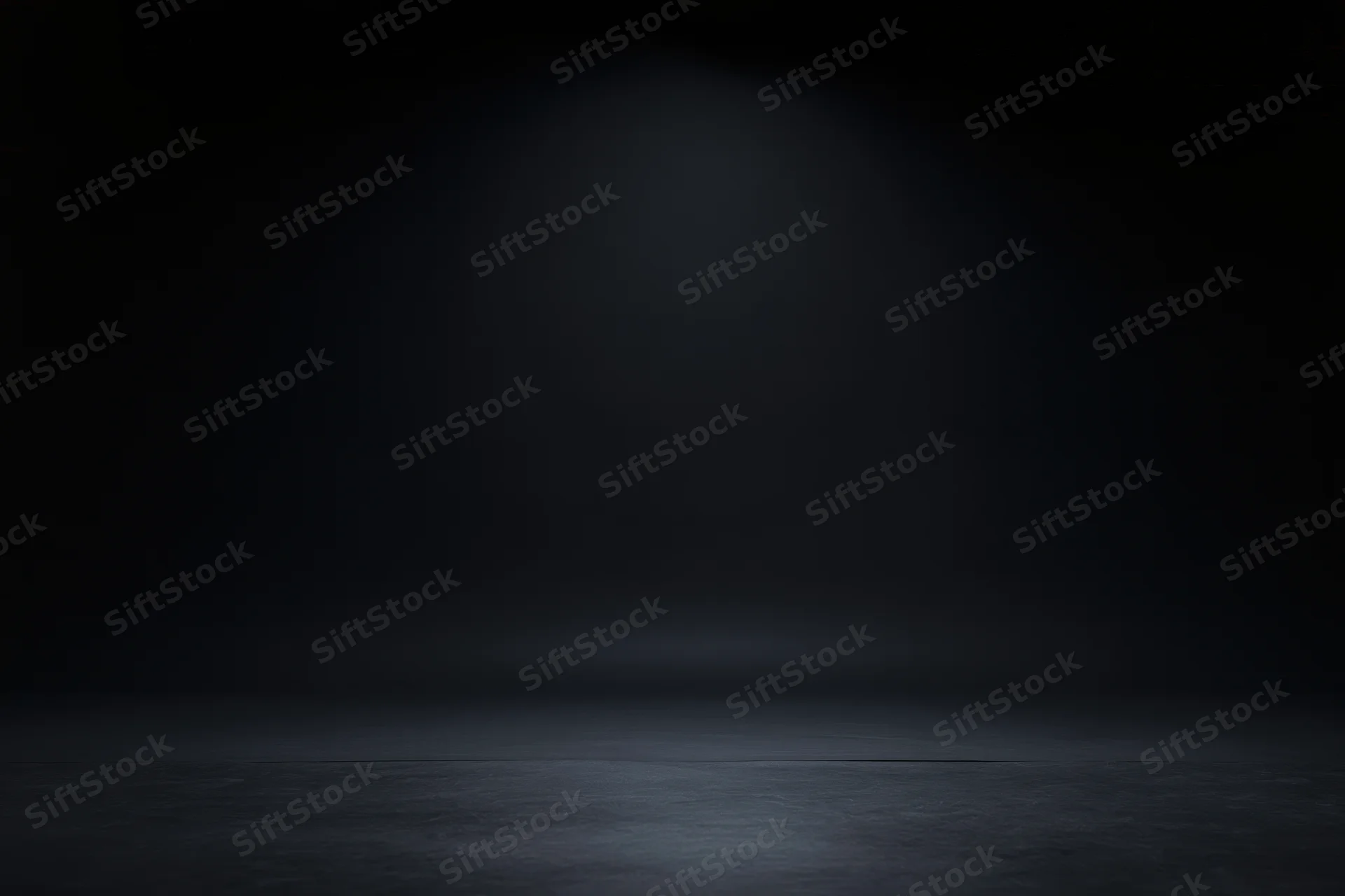 Dark studio space with spotlight on seamless black backdrop and reflective floor