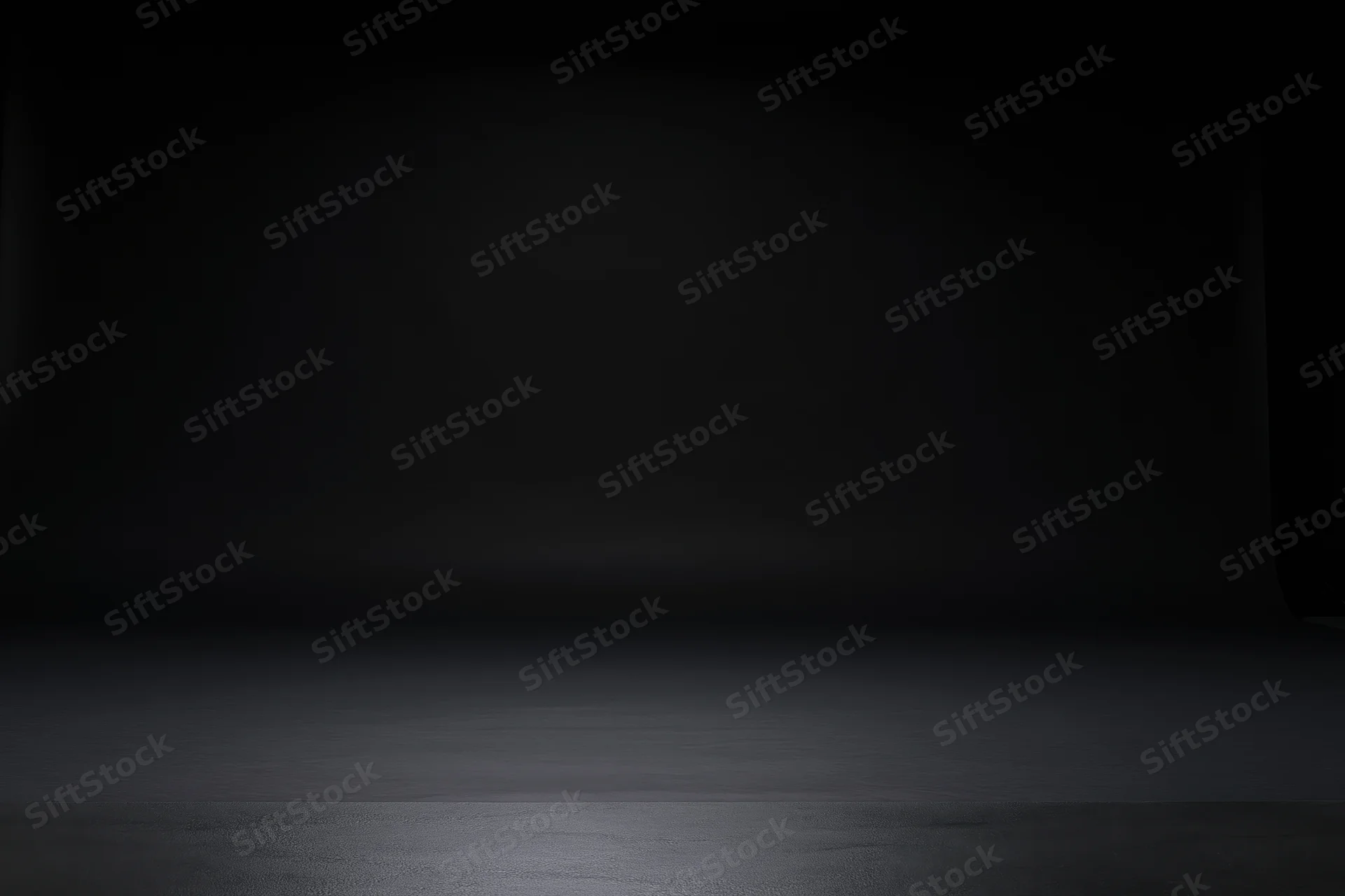 Empty dark studio backdrop with seamless black surface and subtle lighting gradient