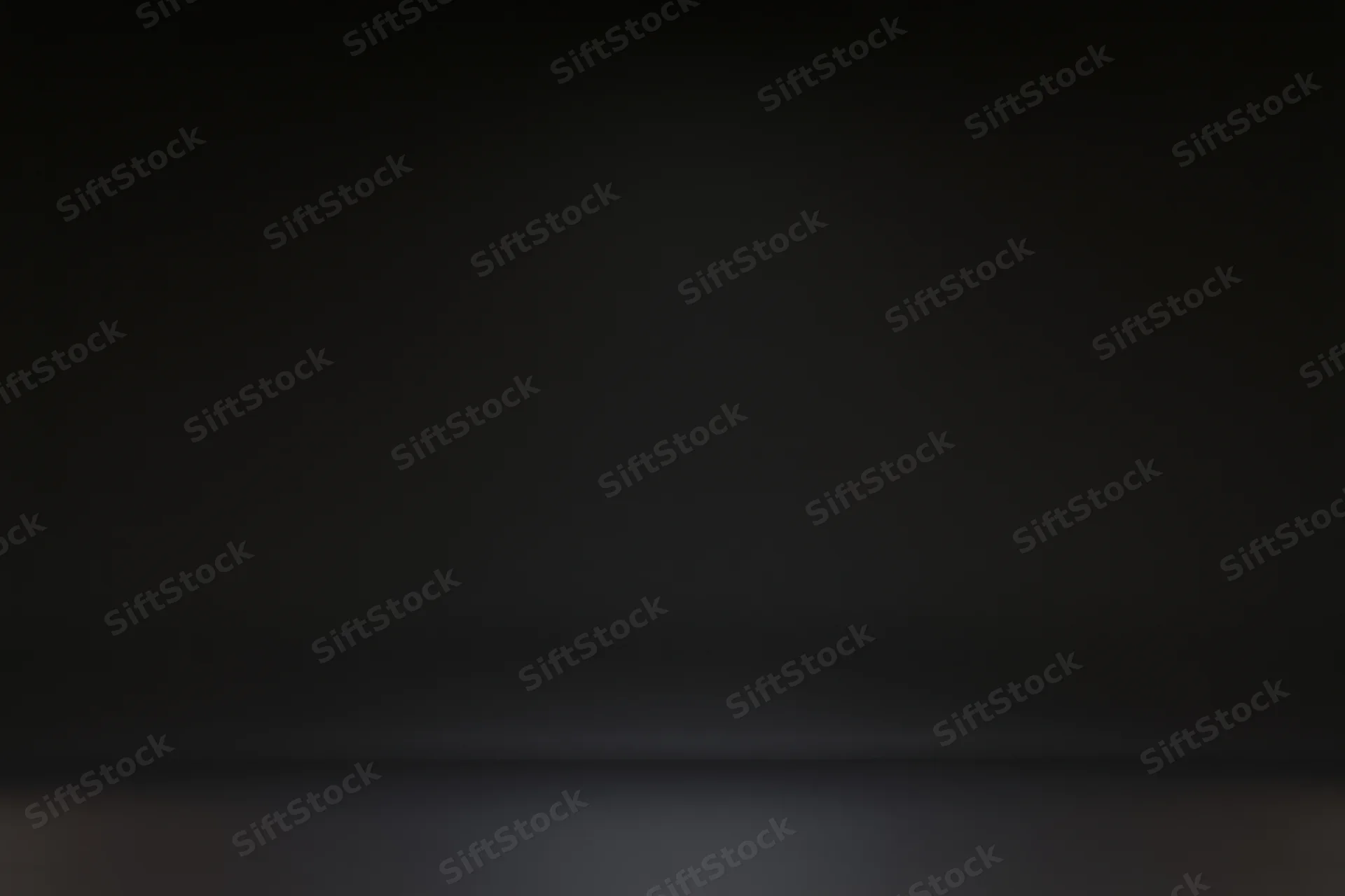 Seamless black studio backdrop with gradient lighting and empty floor space