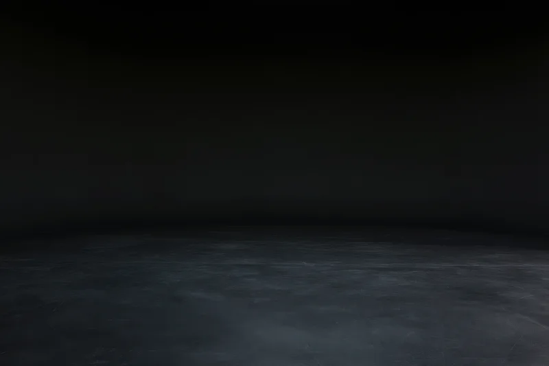Dark studio interior with seamless black wall meeting floor