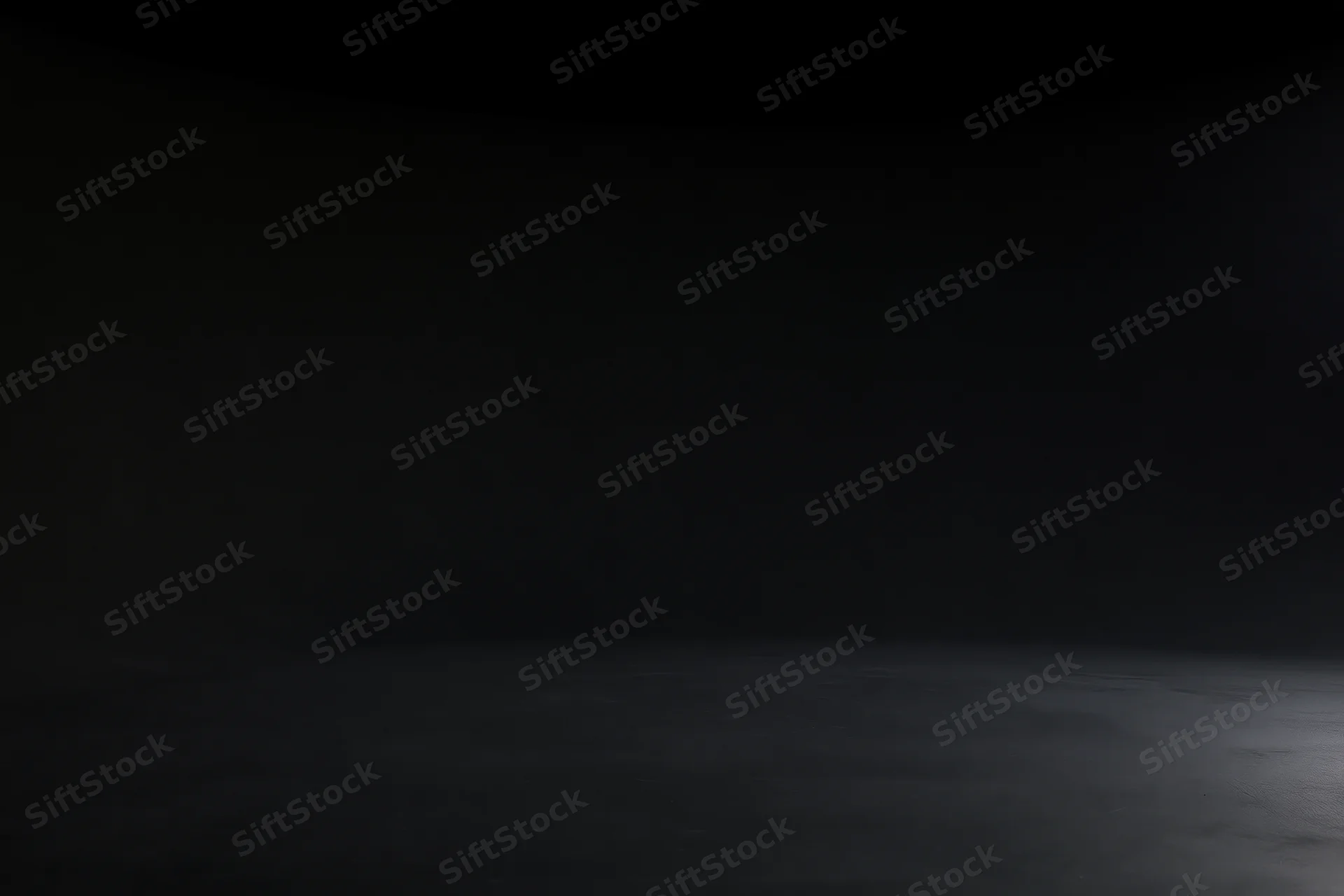 Seamless black studio backdrop with floor meeting wall in dark empty space