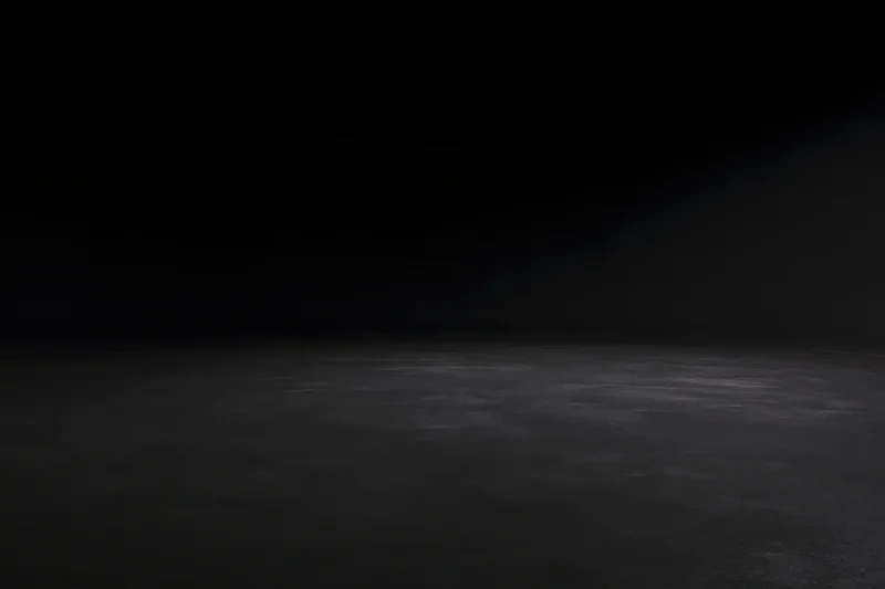 Dark studio interior with seamless black wall meeting floor