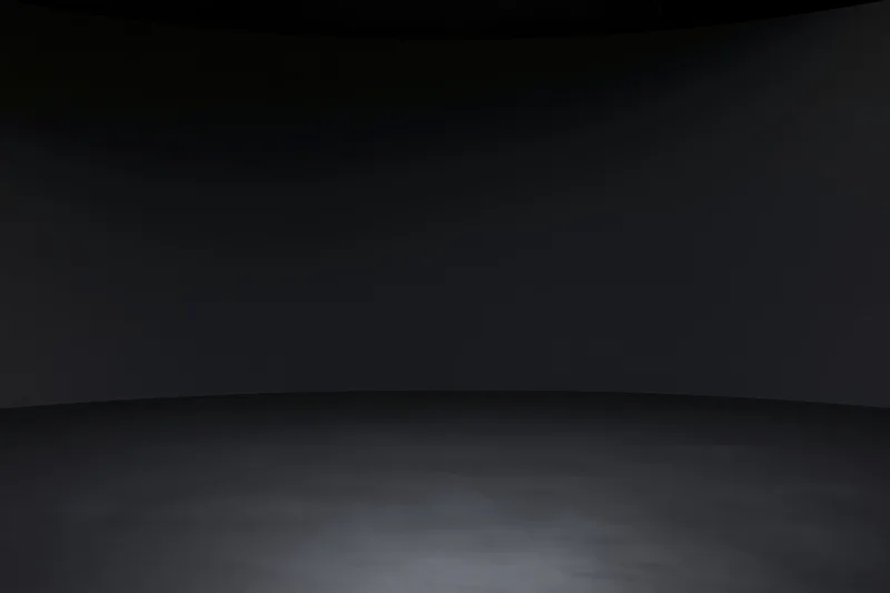 Dark studio interior with seamless black wall meeting floor