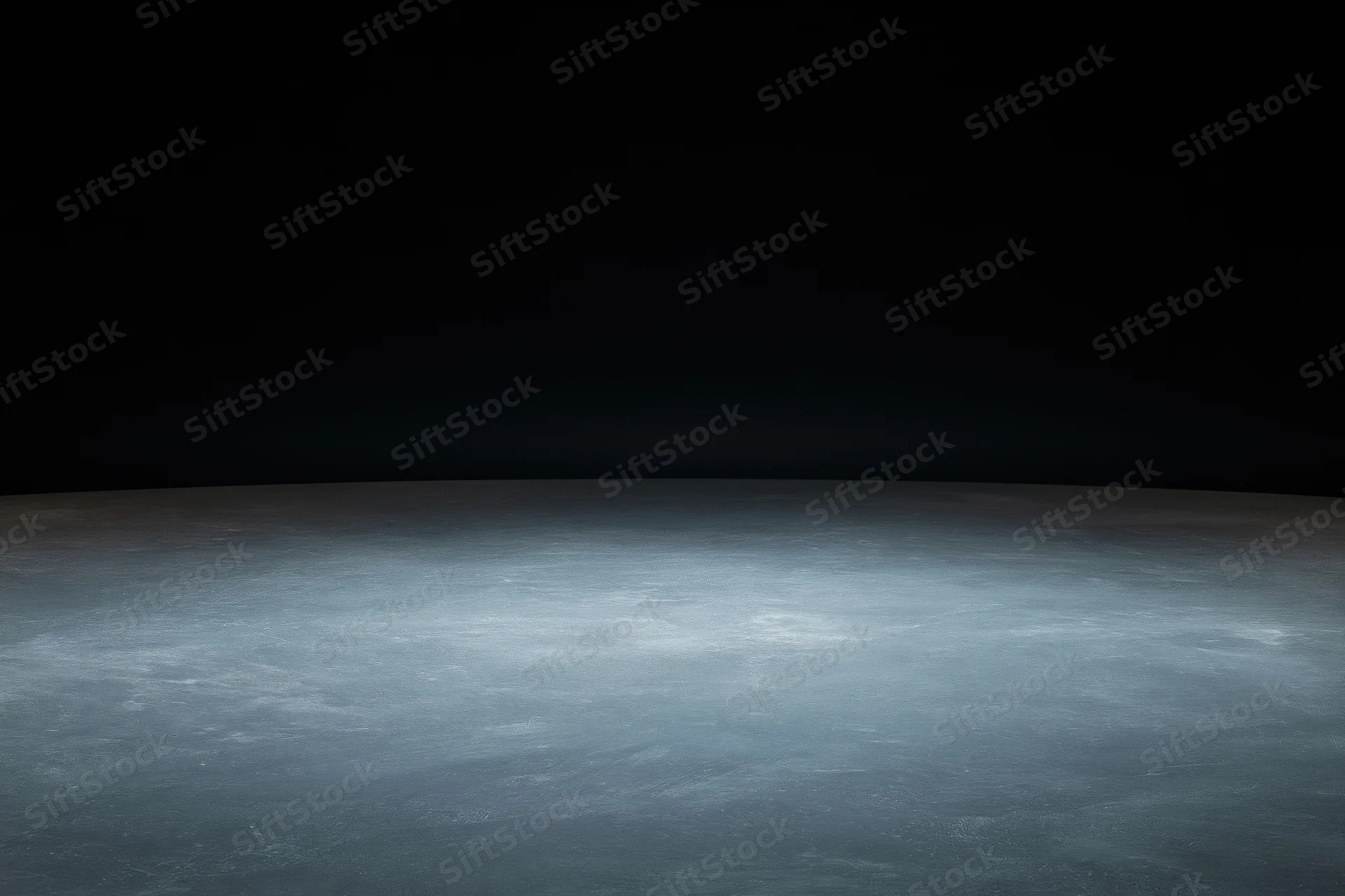Dark studio space with concrete floor lit by soft ambient light