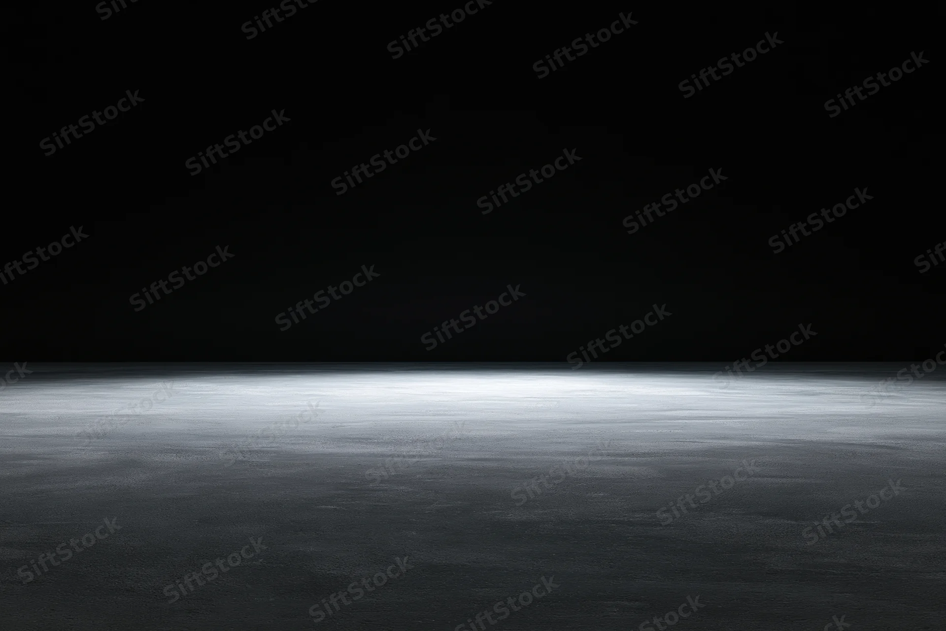 Dark studio interior with spotlighted concrete floor and black backdrop