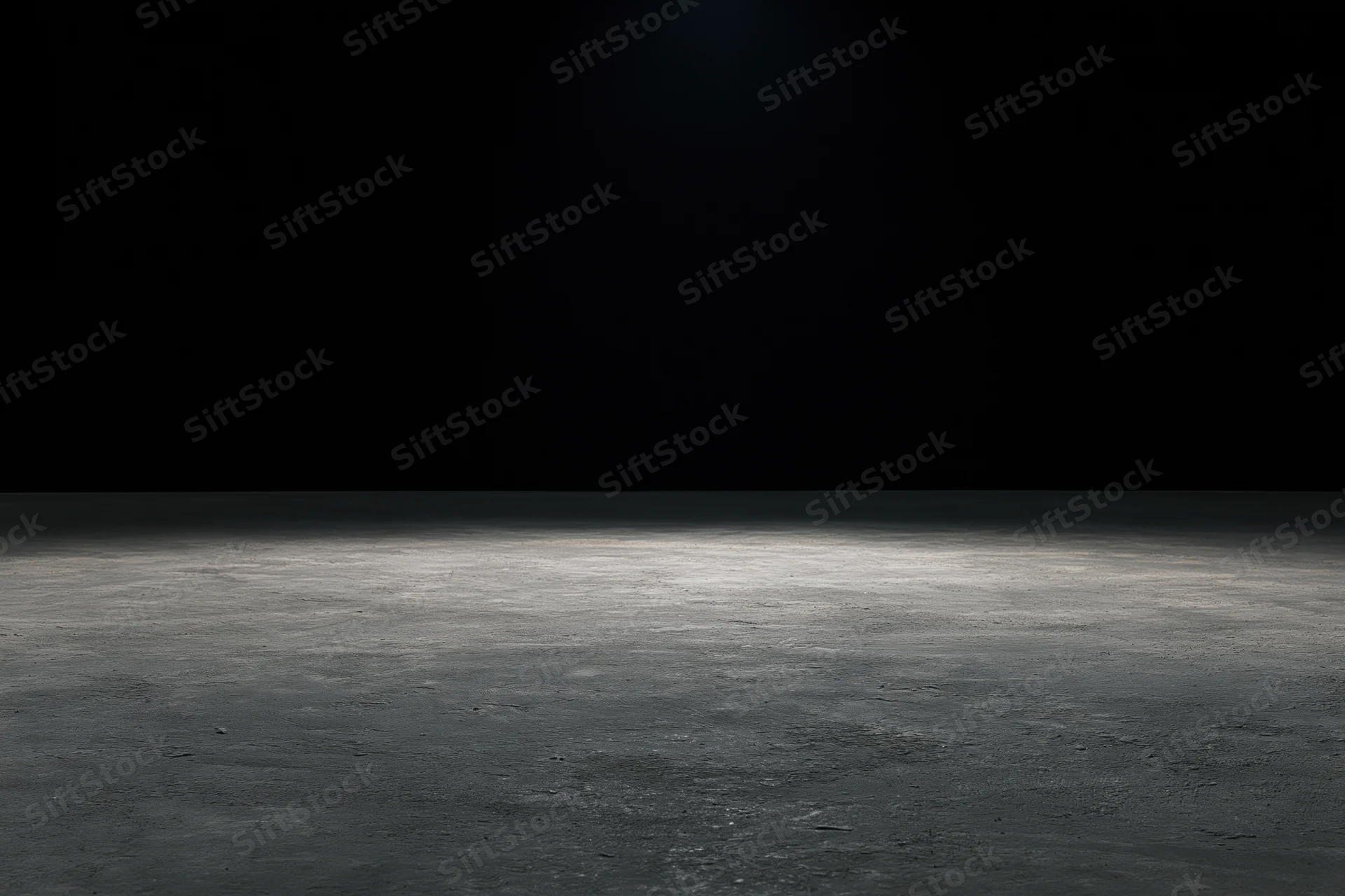 Spotlight on a concrete floor in a dark studio space