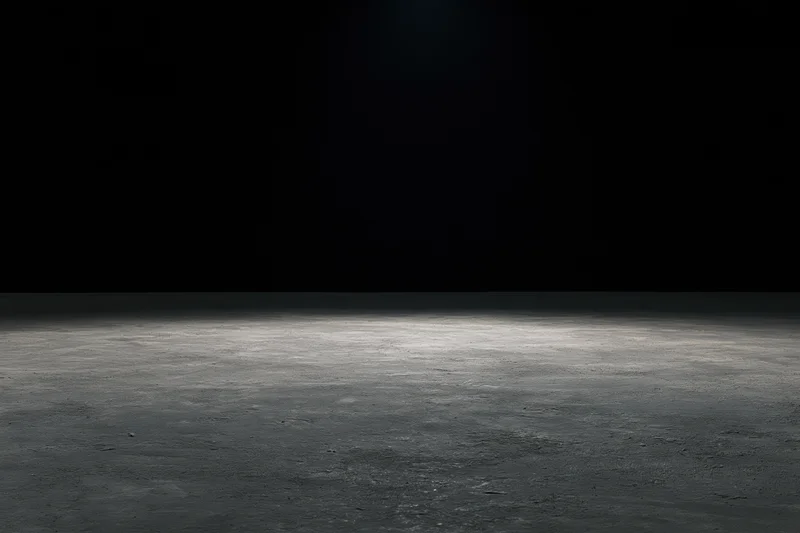 Spotlight on a concrete floor in a dark studio space