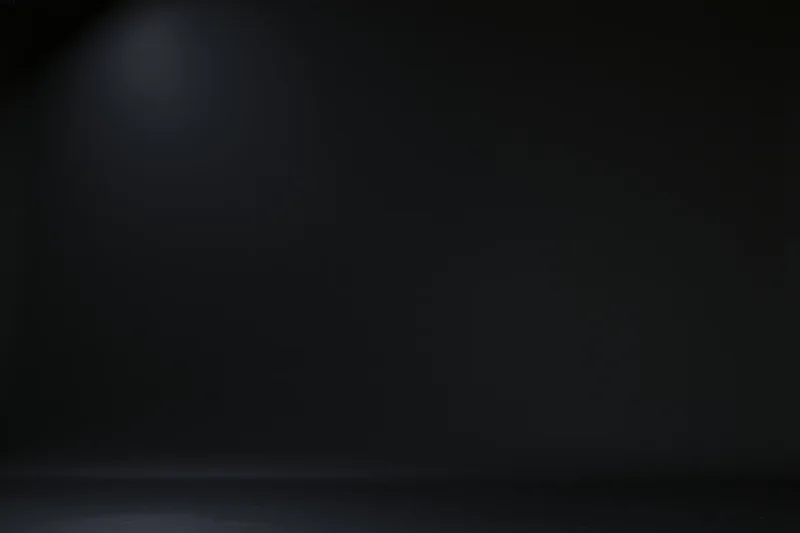 Dark studio backdrop with soft gradient lighting and empty space for product display