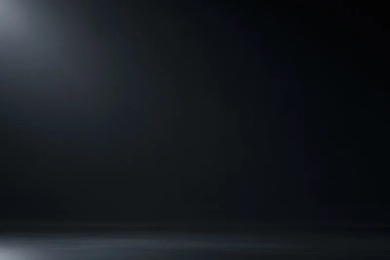Dark studio backdrop with soft gradient lighting and empty floor space
