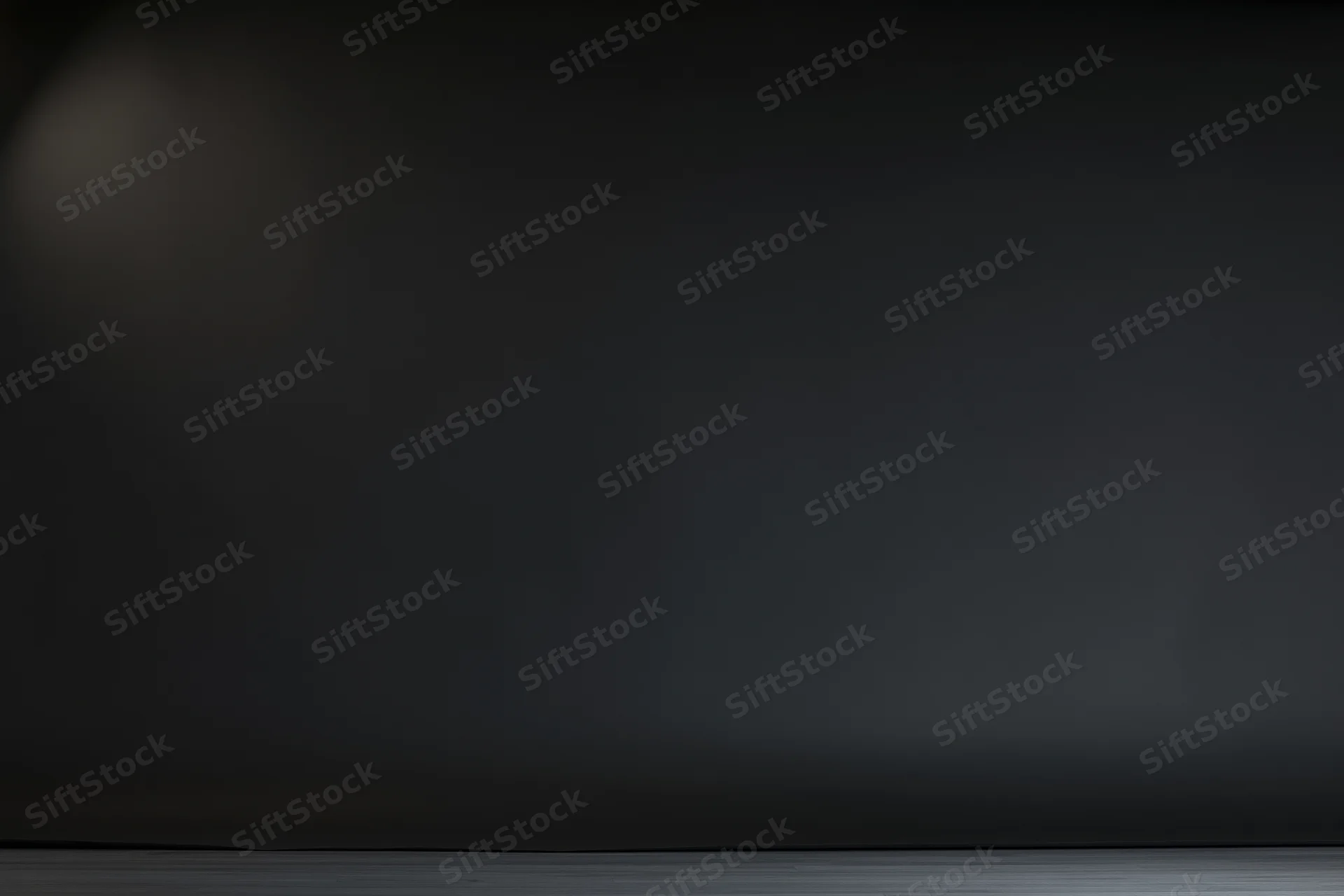 Dark studio backdrop with soft gradient lighting and empty floor space