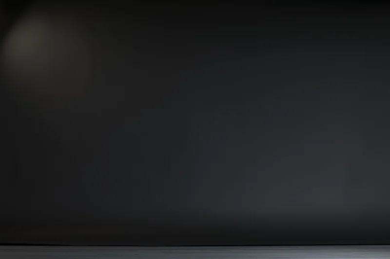 Dark studio backdrop with soft gradient lighting and empty floor space