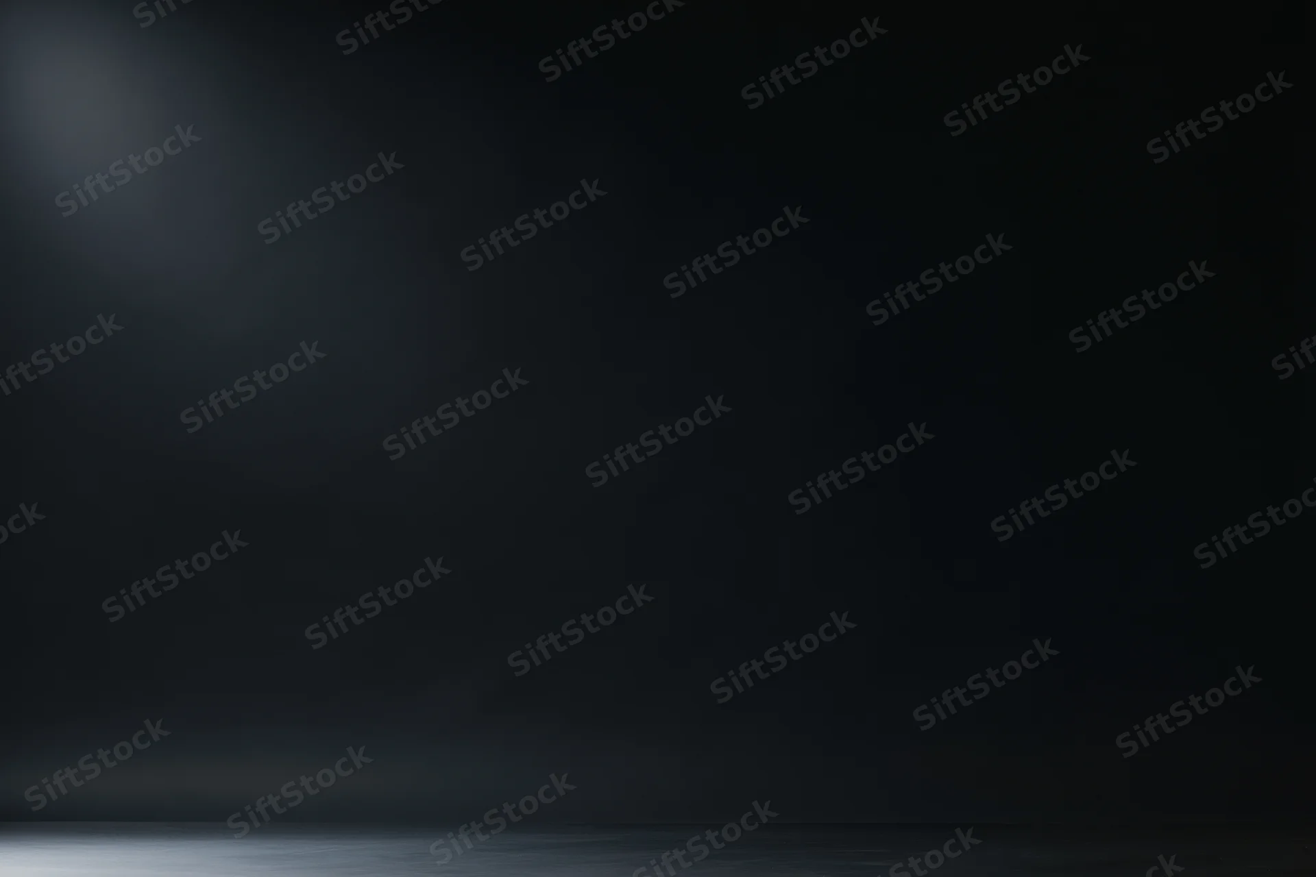 Dark studio backdrop with soft gradient lighting and empty space for display