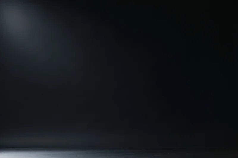 Dark studio backdrop with soft gradient lighting and empty space for display