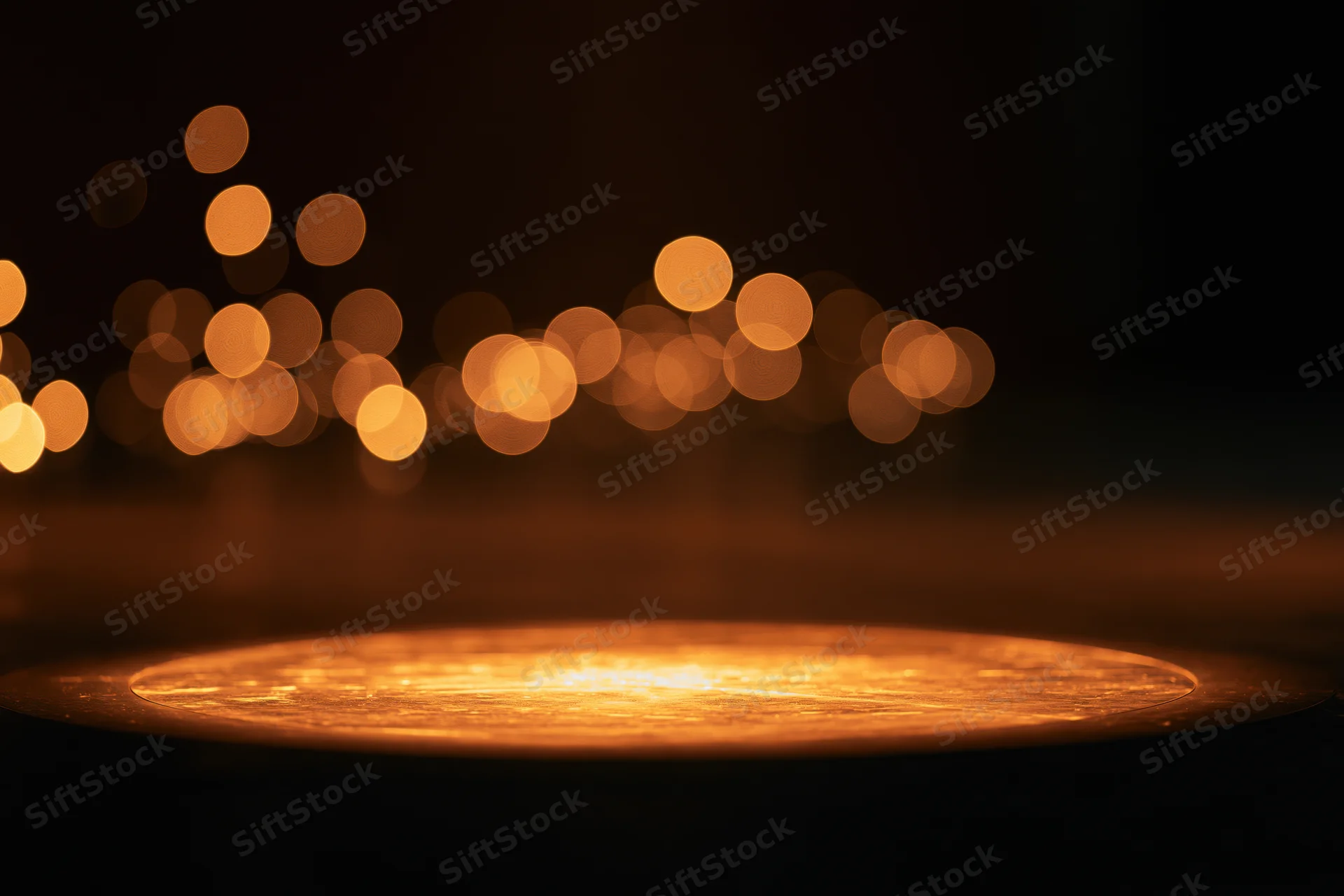 Warm amber spotlight pool on dark studio stage floor with bokeh lights in background