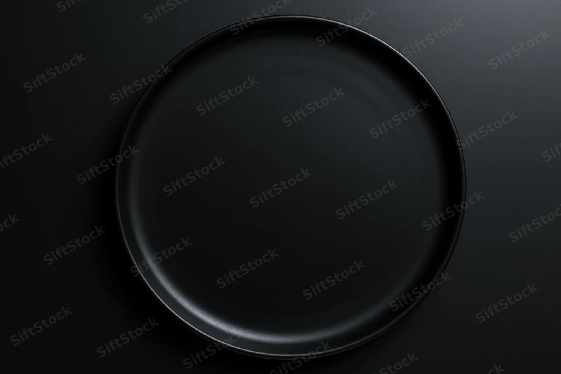 Matte black ceramic dinner plate centered on dark flat surface
