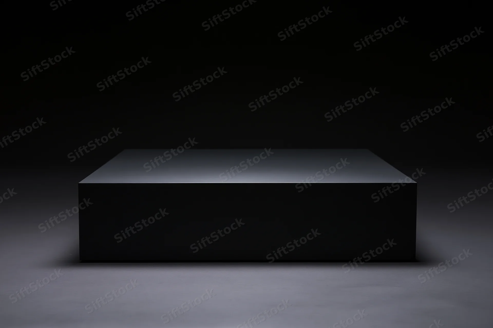 Matte black rectangular pedestal on a dark floor under spotlight lighting
