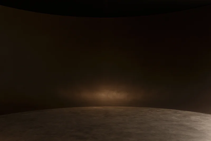Curved seamless studio backdrop with spotlight on dark floor and wall