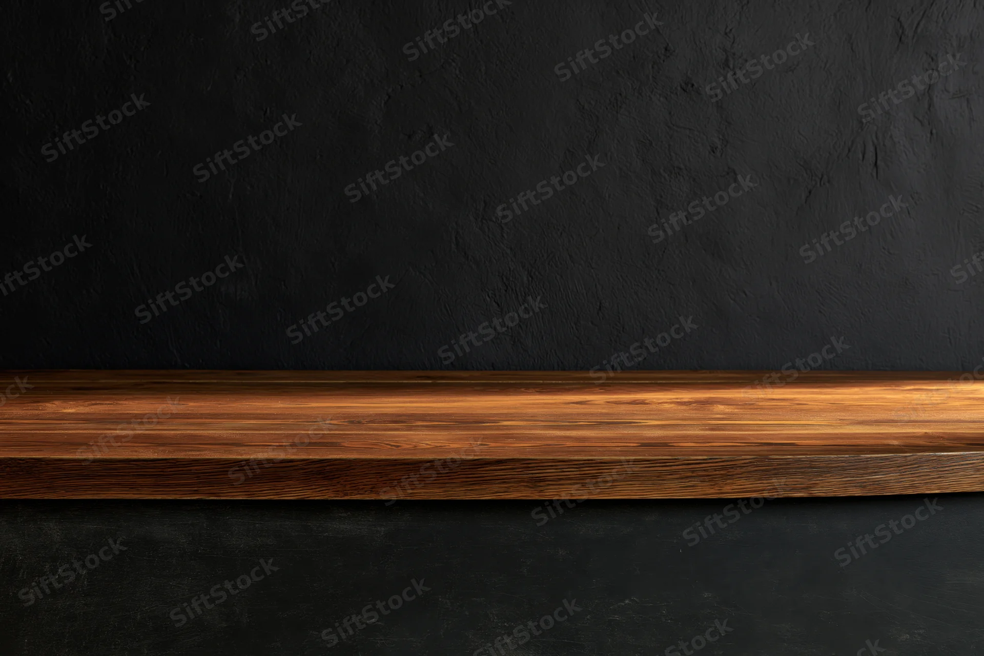 Wooden tabletop surface against dark textured plaster wall