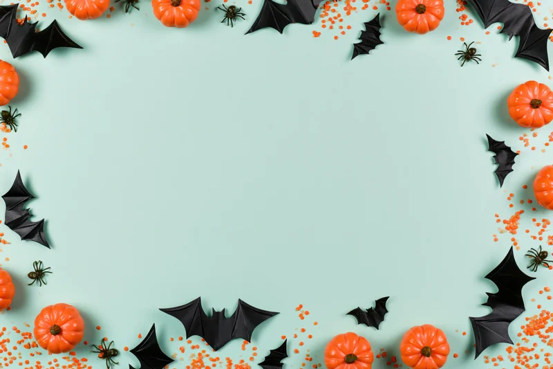 Halloween decorations arranged as a border frame on a mint background with copyspace
