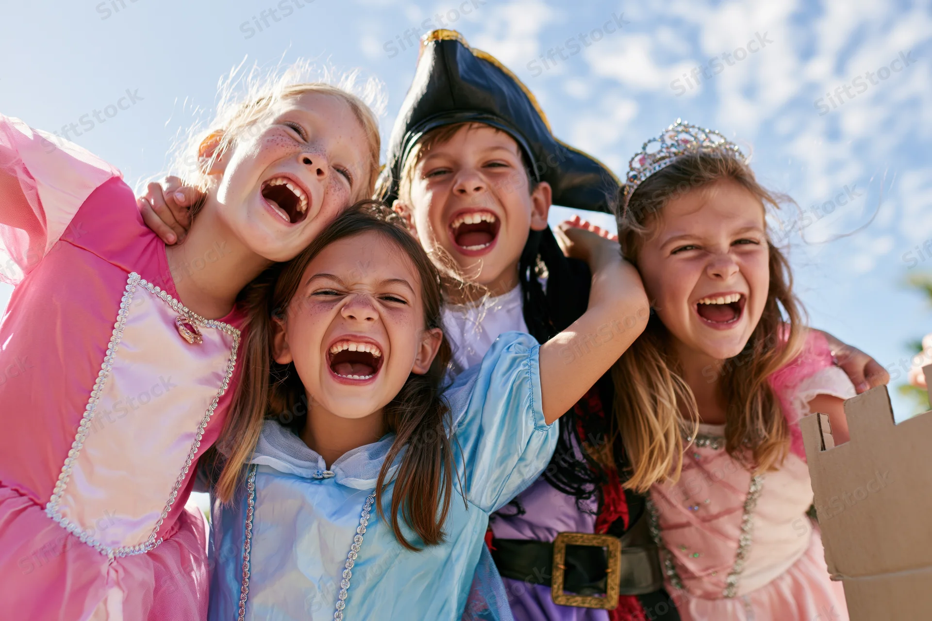 Four children in halloween costumes laughing and shouting outdoors