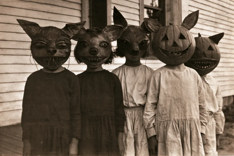 Children wearing oversized handmade halloween masks on a porch